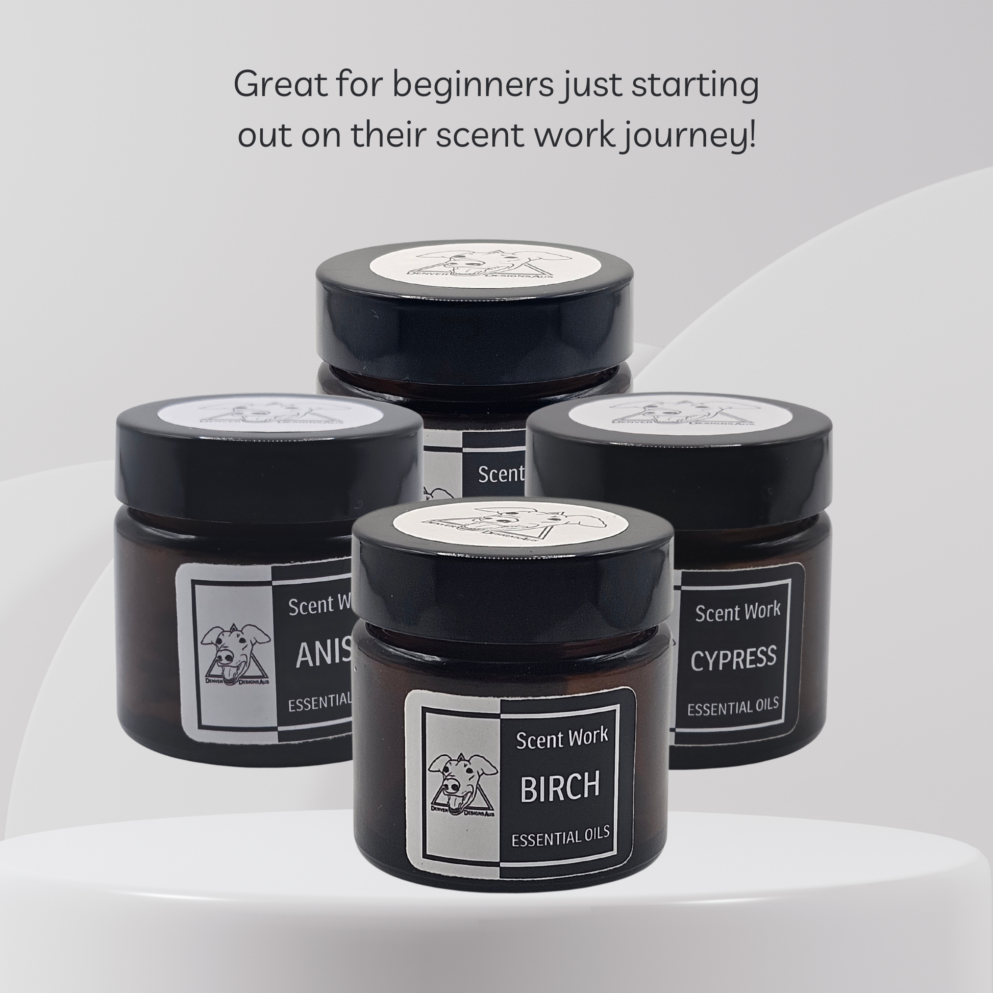 Four black jars with labels on a white background, featuring essential oils.