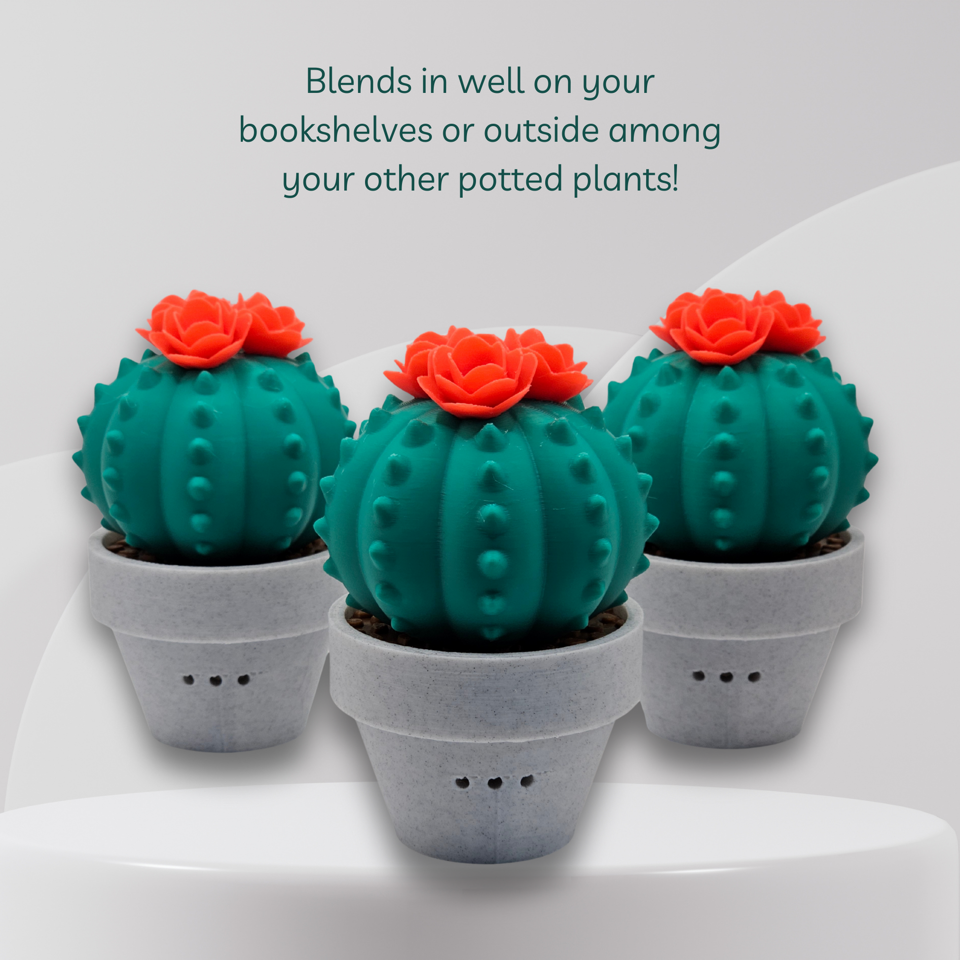 Three green artificial cactus in gray pots on a white surface with text about their use.