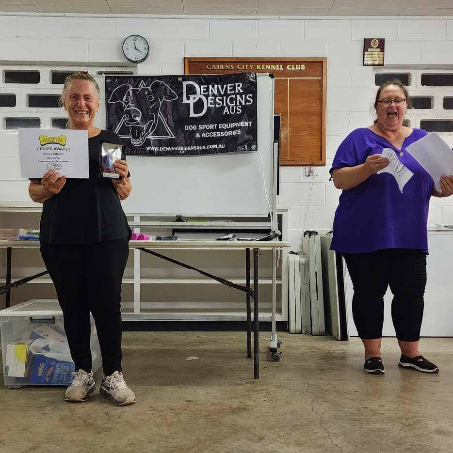 Two people standing in a room holding certificates