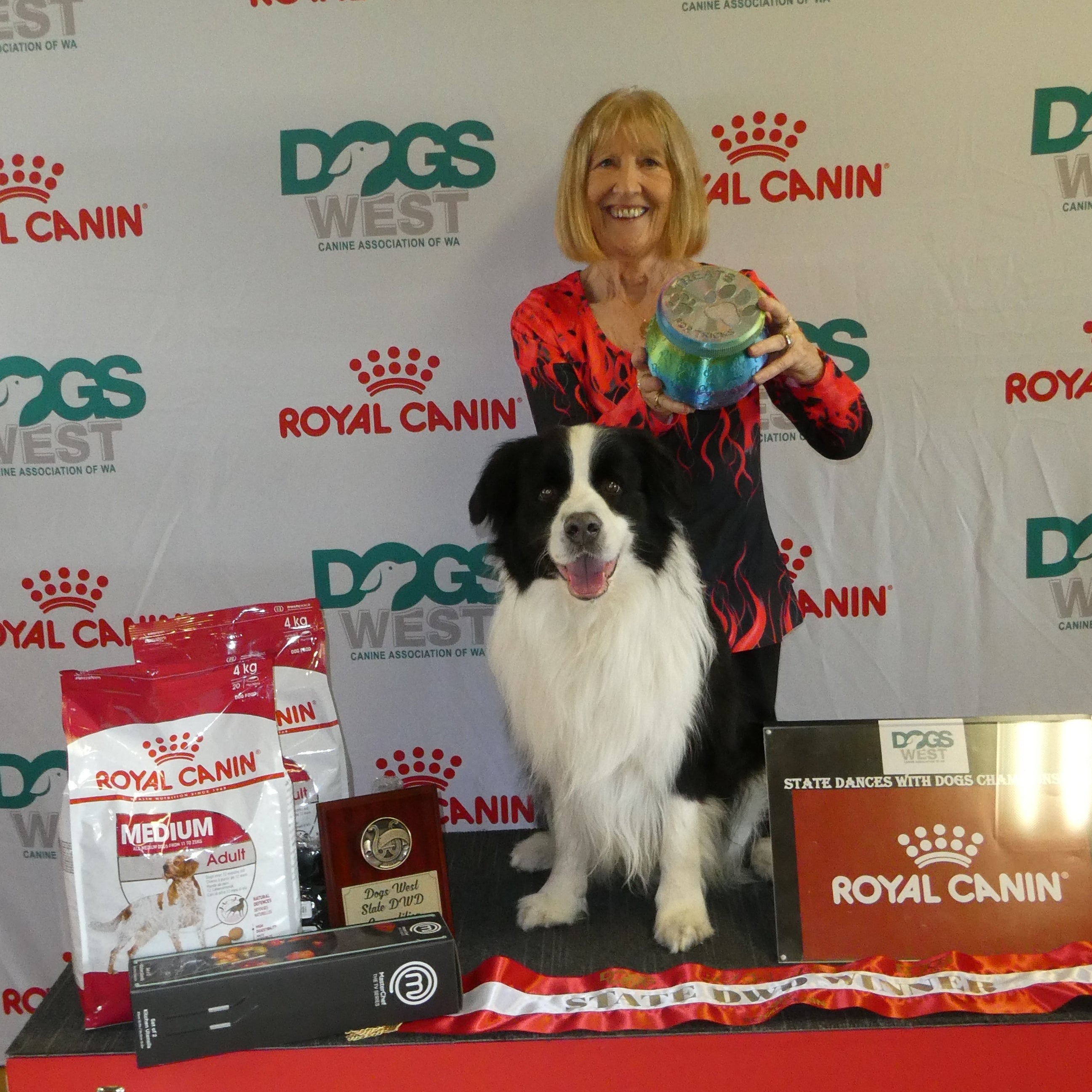 Woman with a dog holding a treat jar in front of a Royal Canin and Dogs West backdrop