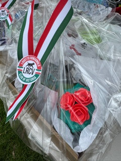 Decorative ribbon with red roses and a logo on a transparent background