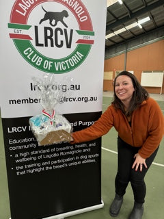 Person standing next to a large LRCV sign in an indoor setting