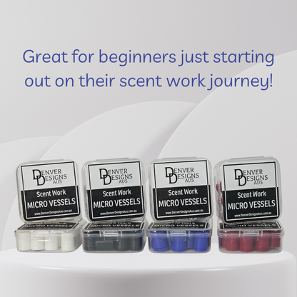 Four small clear plastic boxes of Denver Designs Aus Scent Work Micro Vessels arranged in a row on a white surface, with white, black, blue, and red micro vials visible inside. Blue promotional text at the top reads, 'Great for beginners just starting out on their scent work journey!'.