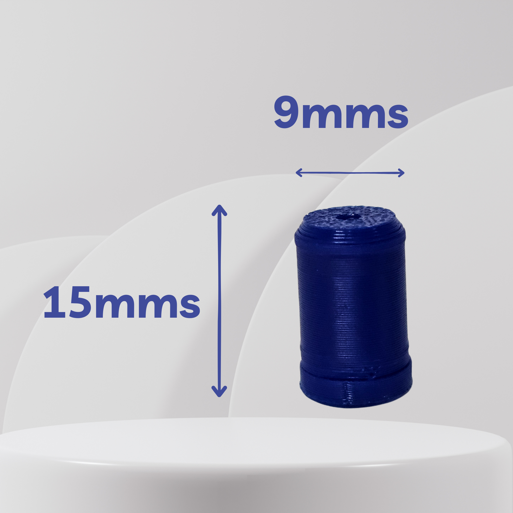 A small dark blue cylindrical product shown floating above a white pedestal with overlaid dimension arrows and text reading 15mms vertically and 9mms horizontally on a light gray background.