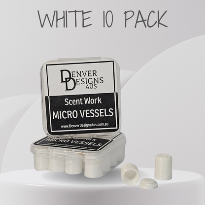 A clear plastic case labeled 'Denver Designs Aus Scent Work Micro Vessels' with a white 'WHITE 10 PACK' text overlay above, showing several small white cylindrical micro vessels and two loose pieces in front on a light gray studio background.