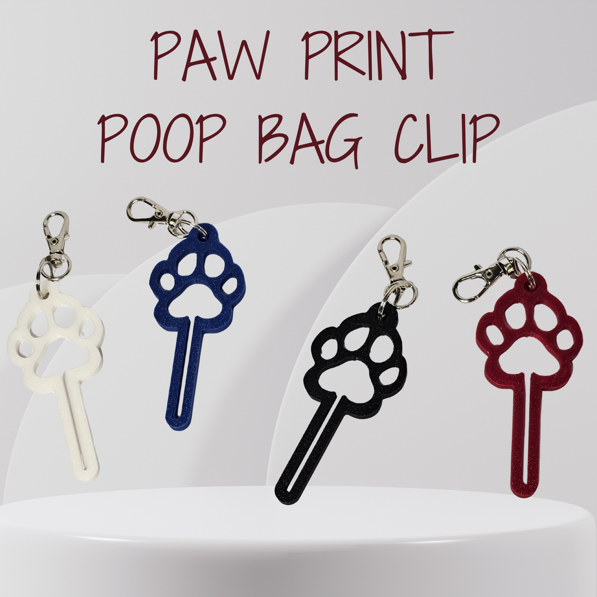 Four paw print shaped poop bag clips in white, blue, black, and red, displayed on a white pedestal with the text 'PAW PRINT POOP BAG CLIP' at the top.