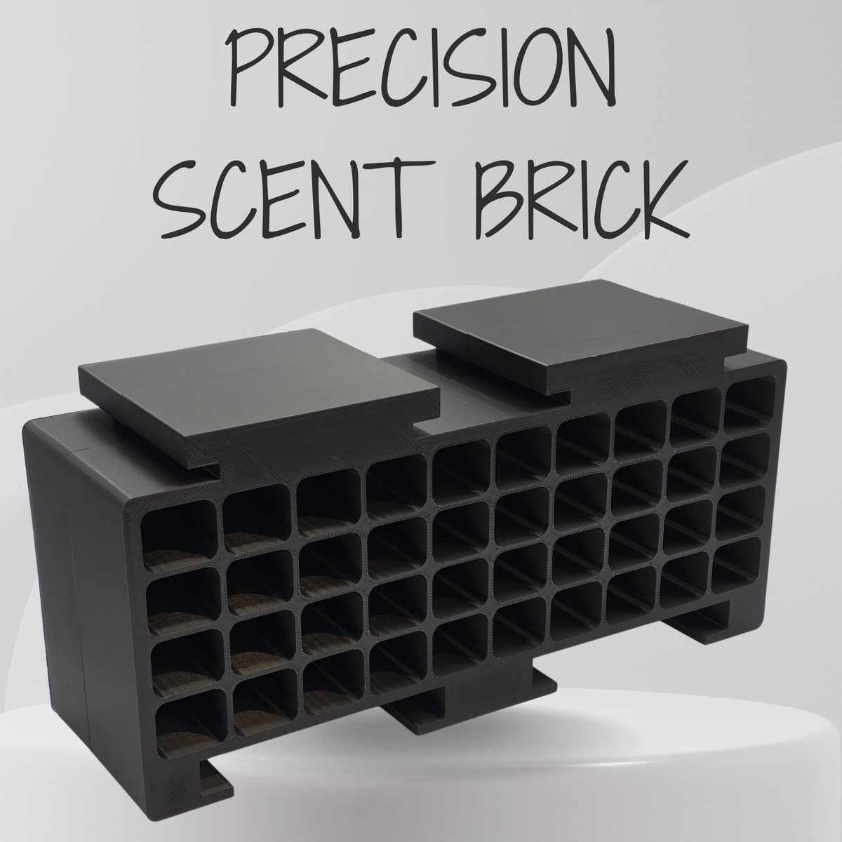 A black precision scent brick with multiple square cavities, shown on a light gray background with the text 'PRECISION SCENT BRICK' above it.