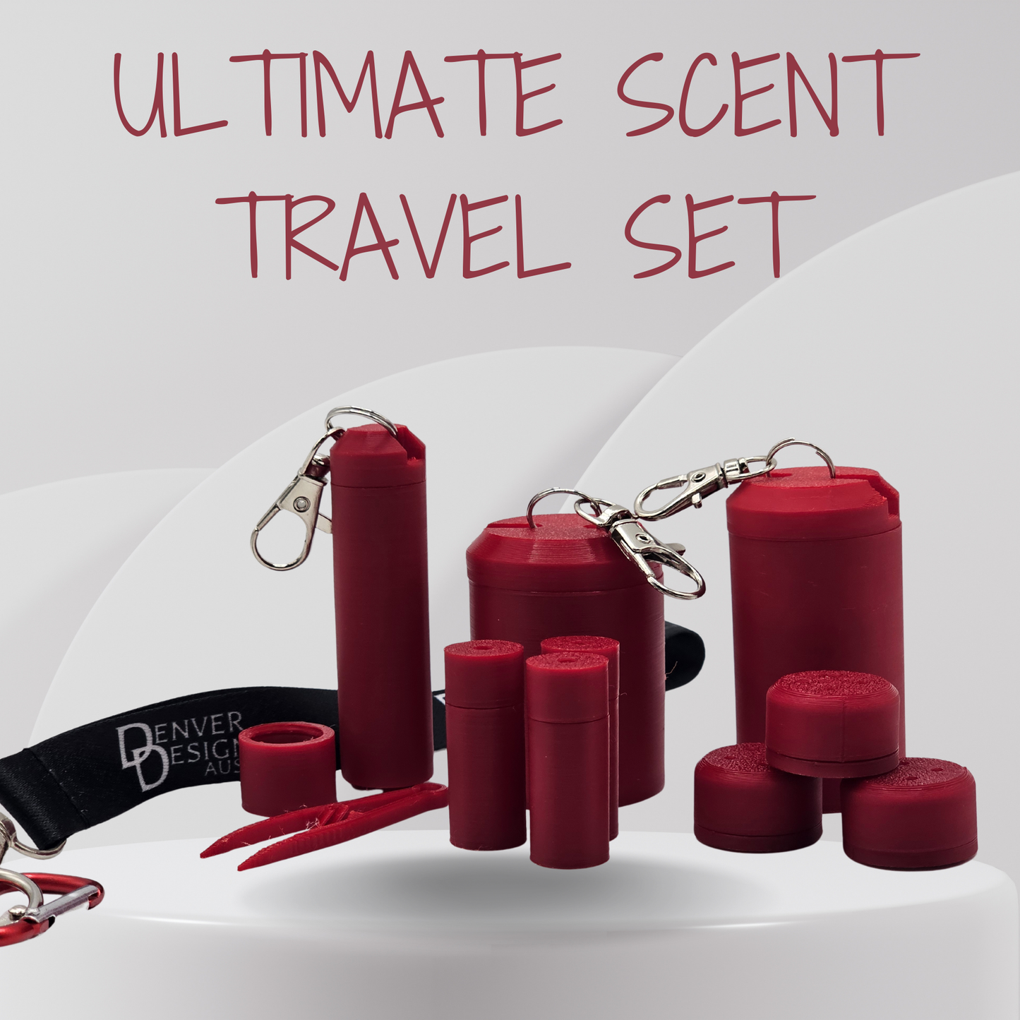 A set of red travel-sized scent vessels containers and accessories, including a black wrist strap with white 'Denver Design' branding, metal keychains, a small red tool, and several balm tubes, arranged on a white surface with the text 'ULTIMATE SCENT TRAVEL SET' above.