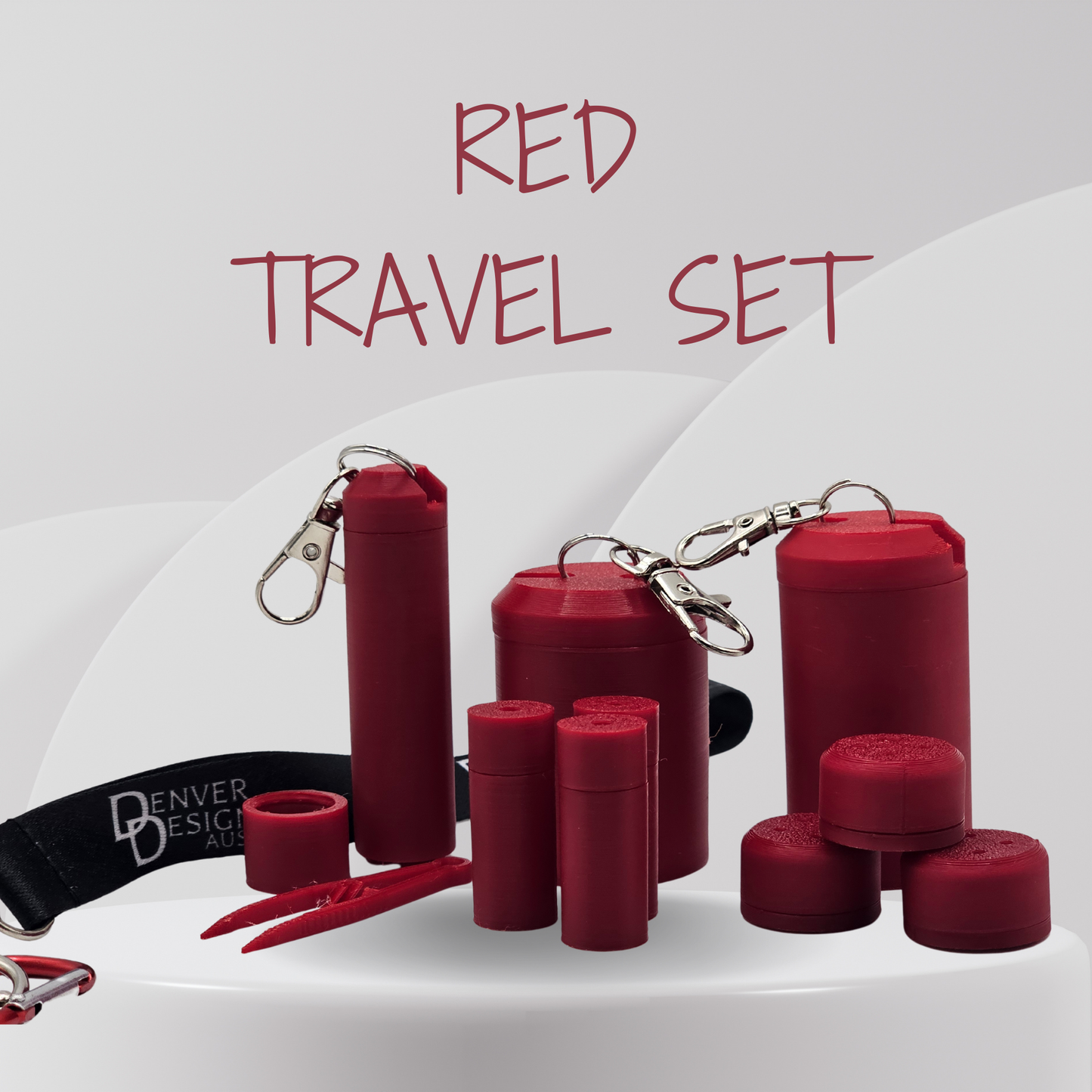 A red travel set containing multiple cylindrical containers and accessories, including a black wrist strap with white 'Denver Design' branding, arranged on a white surface with a light gray background and the text 'RED TRAVEL SET' at the top.